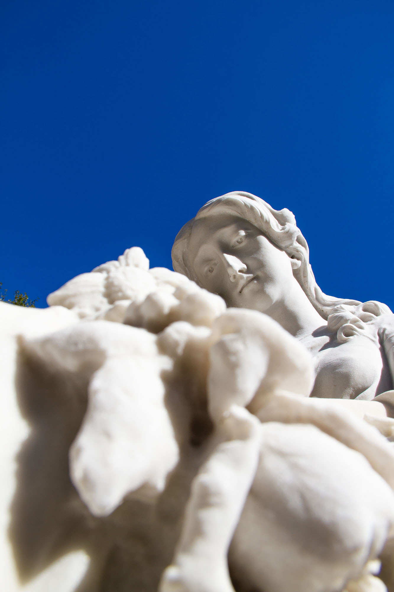 Marble woman looking down with blue sky